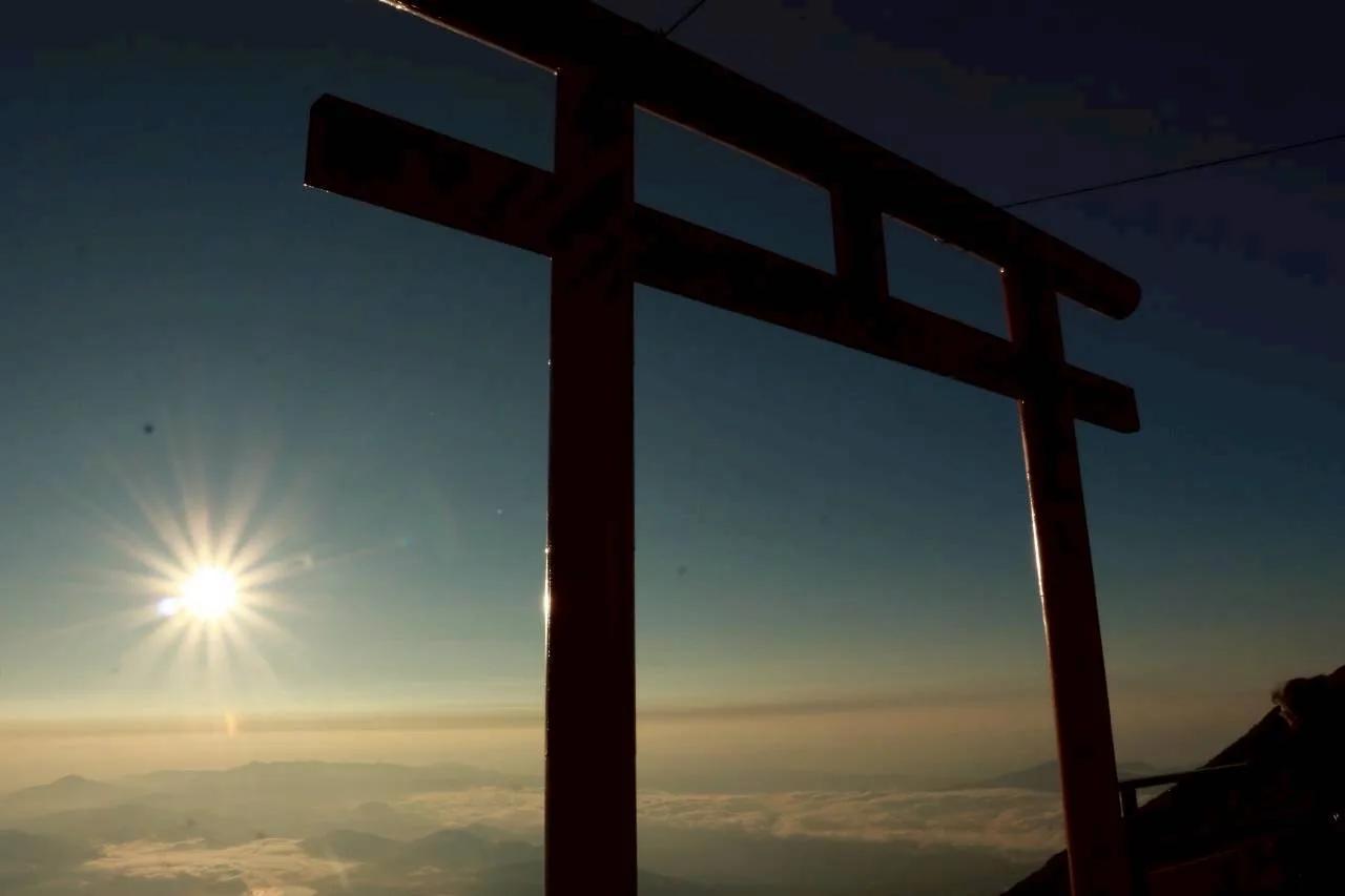 山中の鳥居の向こうに昇る朝日と、眼下に広がる雲海