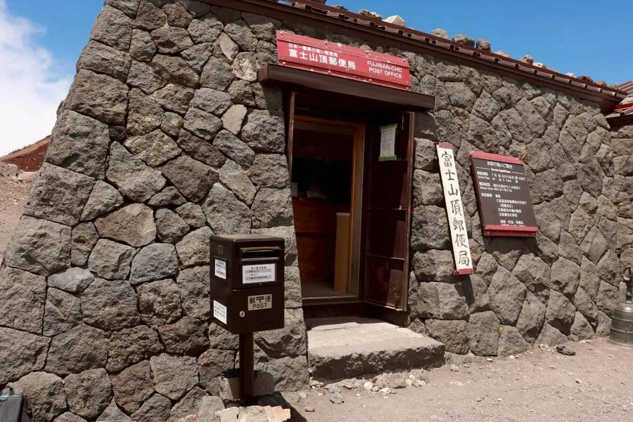 「富士山頂郵便局」の石造りの建物と、その前の郵便ポスト