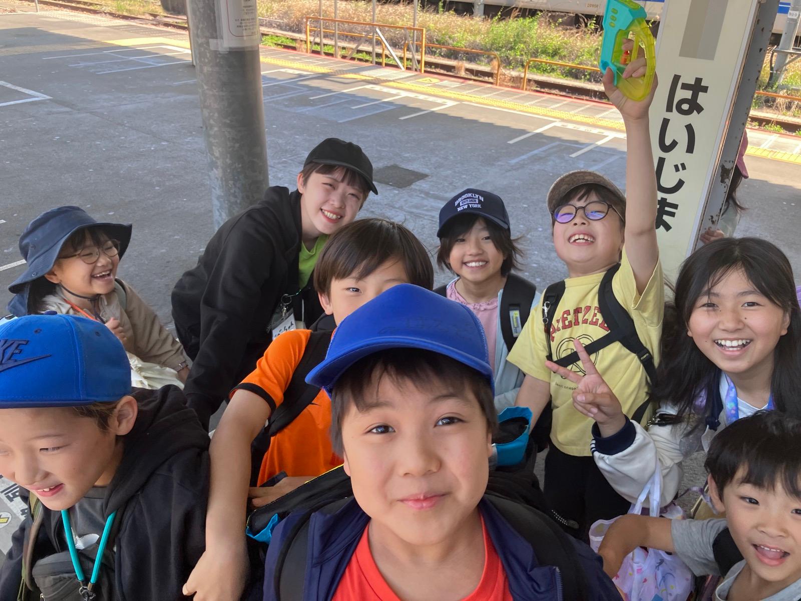 乗り換えの駅のホーム。水鉄砲を掲げて笑う子どもたち