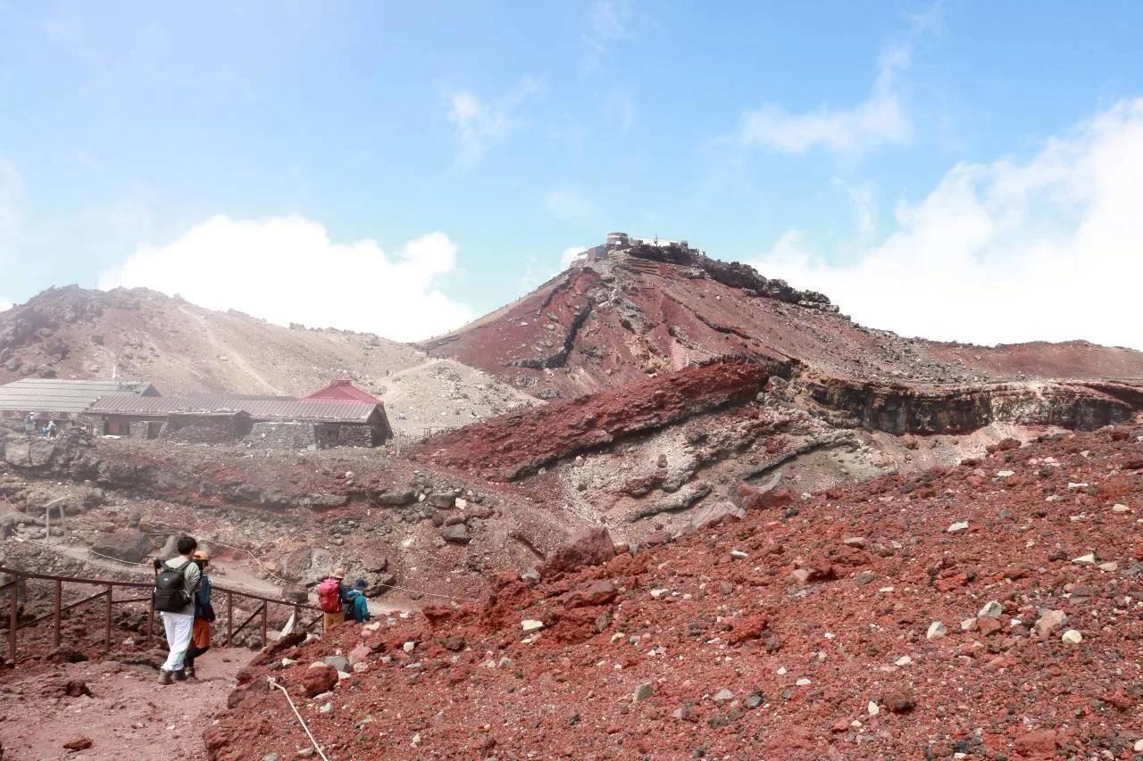 富士山頂の火口と、その縁に建つ山小屋
